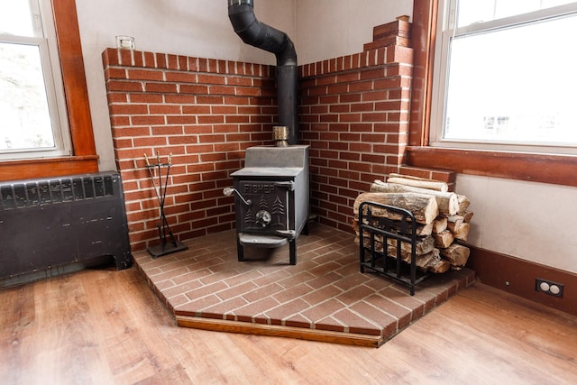 details featuring radiator heating unit, wood-type flooring, and a wood stove