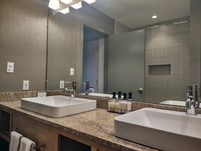 bathroom featuring walk in shower and vanity