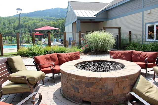 view of patio featuring a mountain view and an outdoor living space with a fire pit