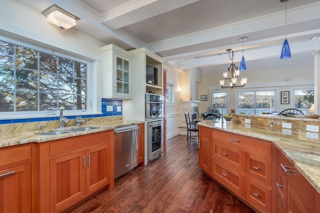 kitchen featuring sink, hanging light fixtures, white cabinets, stainless steel dishwasher, and beamed ceiling