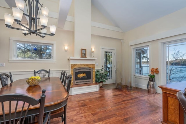 dining space featuring dark hardwood / wood-style flooring, a notable chandelier, and high vaulted ceiling