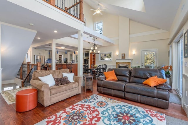 living room with dark wood-type flooring, high vaulted ceiling, and an inviting chandelier