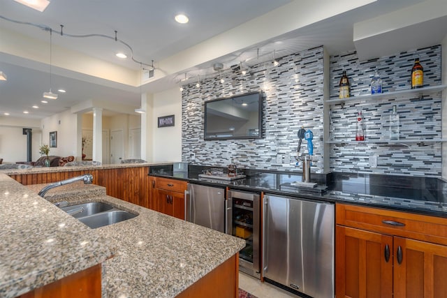 kitchen featuring fridge, sink, light stone counters, and wine cooler