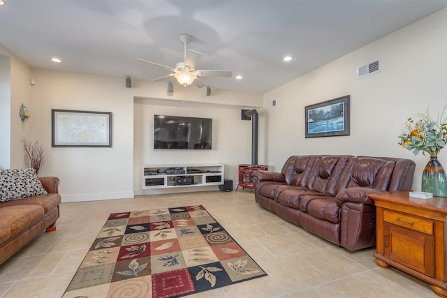 living room with ceiling fan and a wood stove