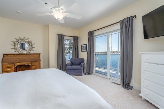 carpeted bedroom featuring a water view, access to outside, and ceiling fan