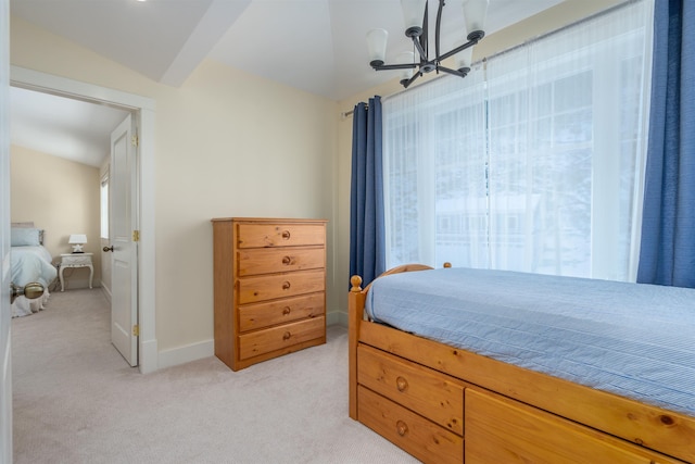 bedroom with multiple windows, light carpet, and an inviting chandelier