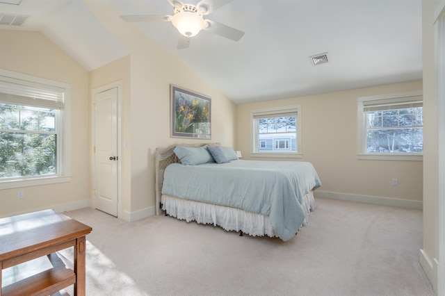 bedroom featuring multiple windows, lofted ceiling, and light carpet