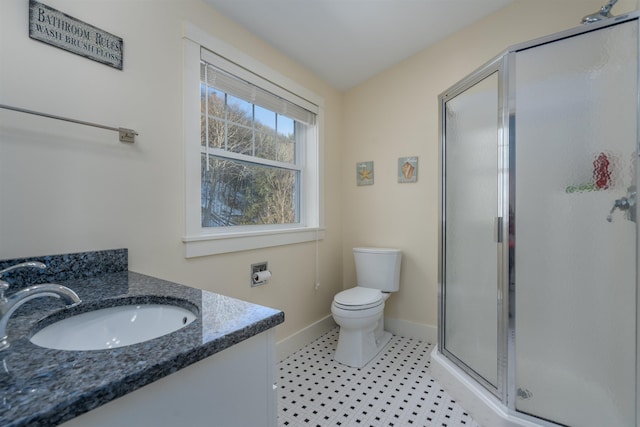 bathroom featuring vanity, toilet, and a shower with shower door