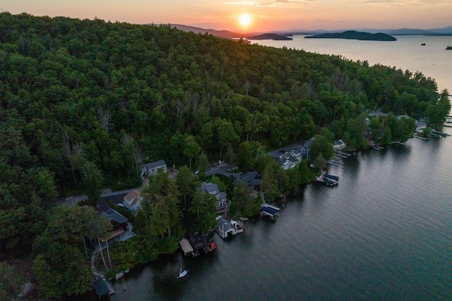 aerial view at dusk featuring a water view