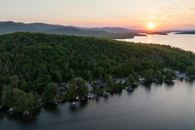 aerial view at dusk featuring a water and mountain view