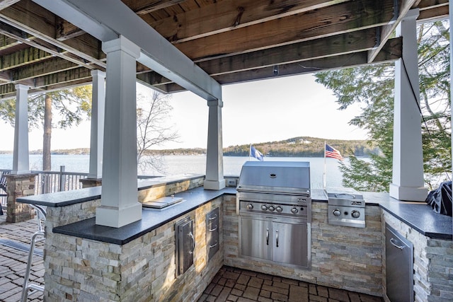 view of patio / terrace featuring area for grilling, a grill, and a water view