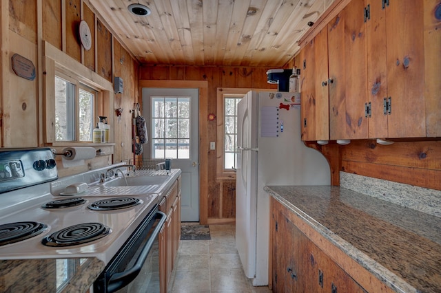 kitchen featuring electric stove, sink, wood ceiling, white fridge, and wood walls