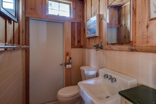 bathroom featuring tile walls, sink, and toilet