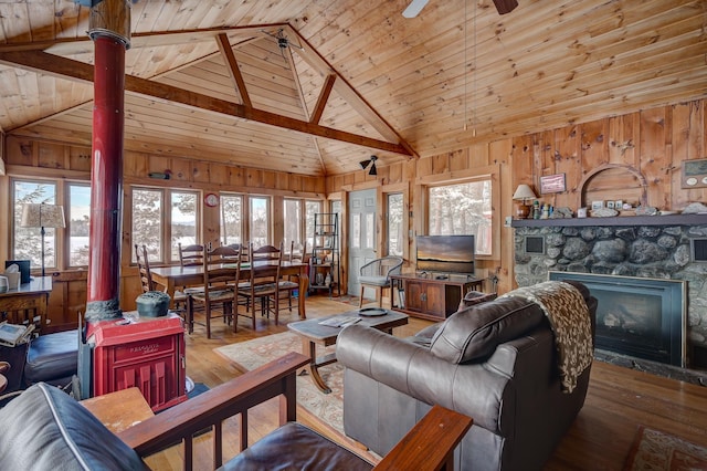 living room with hardwood / wood-style flooring, wood ceiling, a fireplace, and wood walls