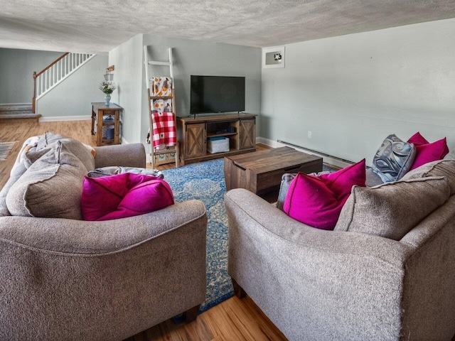 living room with a baseboard heating unit, wood-type flooring, and a textured ceiling