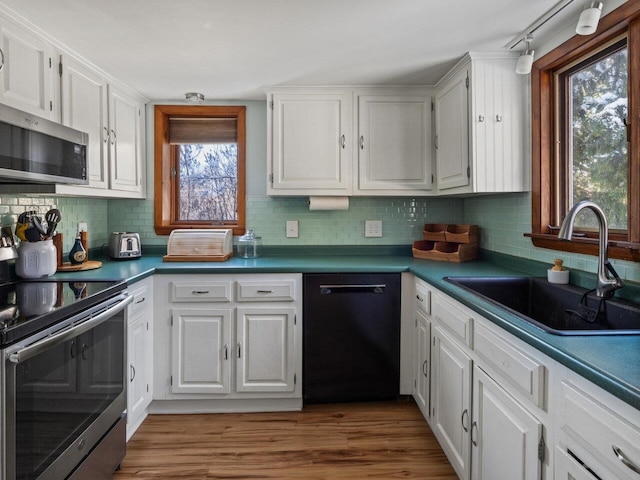 kitchen featuring white cabinetry, appliances with stainless steel finishes, sink, and plenty of natural light