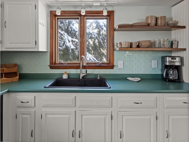 kitchen featuring tasteful backsplash, sink, and white cabinets