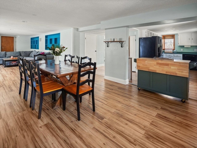 dining room featuring a textured ceiling and light wood-type flooring