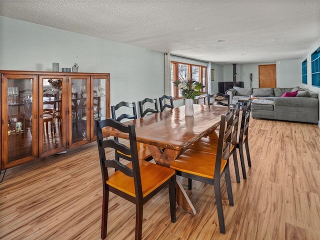 dining space with a textured ceiling and light hardwood / wood-style floors