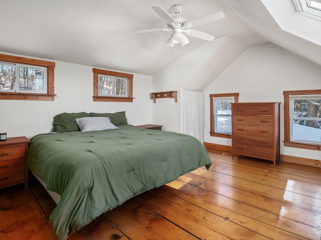 bedroom featuring hardwood / wood-style flooring, lofted ceiling, and multiple windows