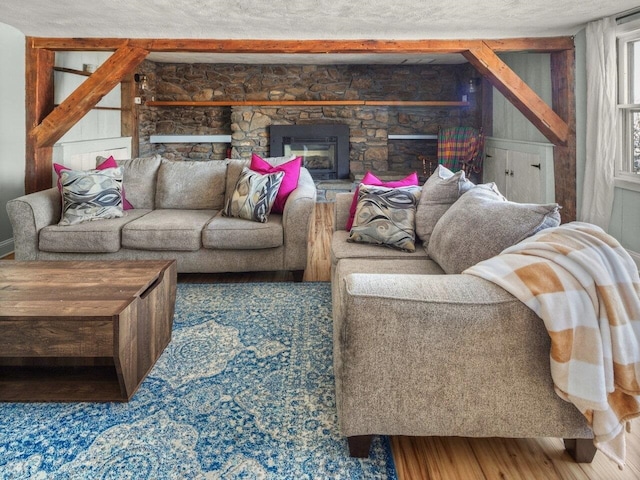 living room with hardwood / wood-style floors, a fireplace, and a textured ceiling