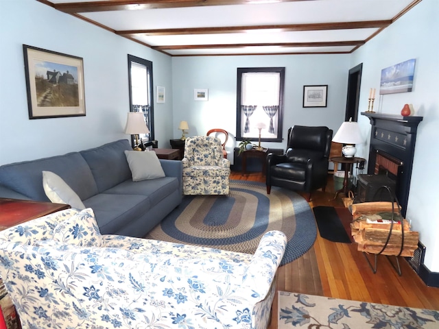 living room with beamed ceiling, plenty of natural light, and hardwood / wood-style floors