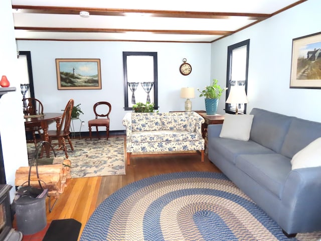 living room with beamed ceiling, a wealth of natural light, and hardwood / wood-style floors