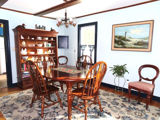 dining area with a notable chandelier, wood-type flooring, and ornamental molding