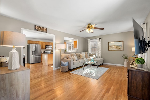 living room with ceiling fan and light wood-type flooring