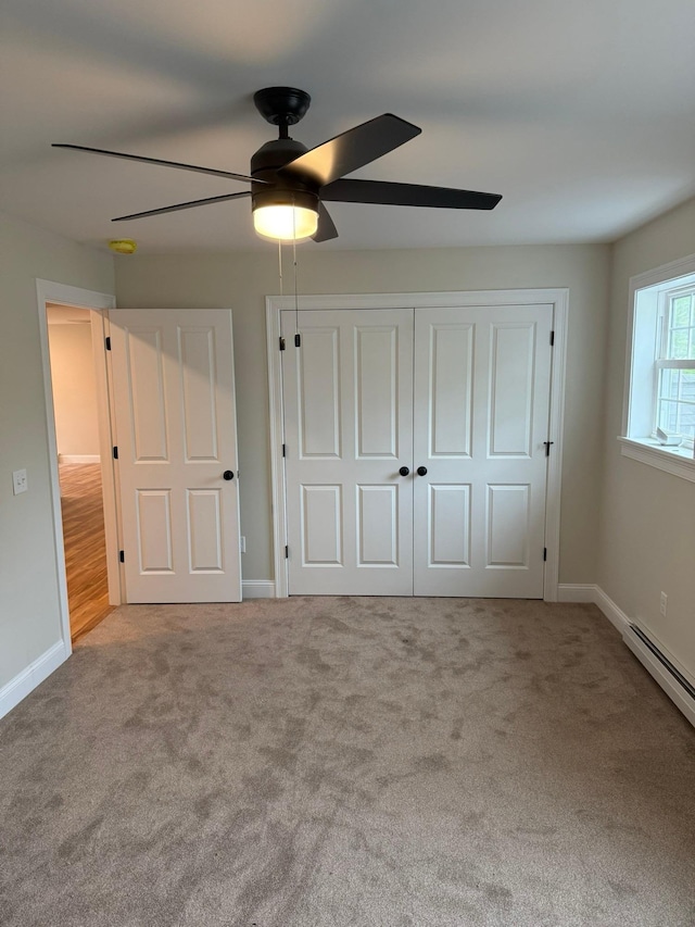 7 Willys Ln Unit 104, Milton, VT 05468 - unfurnished bedroom with carpet floors, baseboards, a closet, a baseboard heating unit, and a ceiling fan