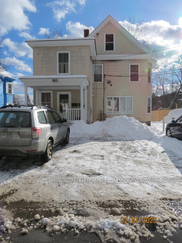 snow covered property featuring covered porch