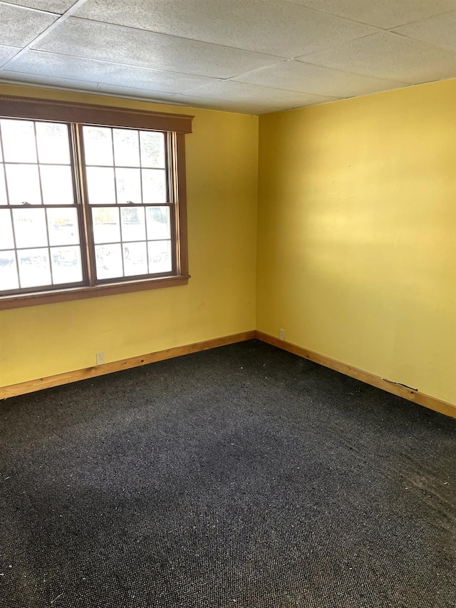 empty room with a paneled ceiling and carpet