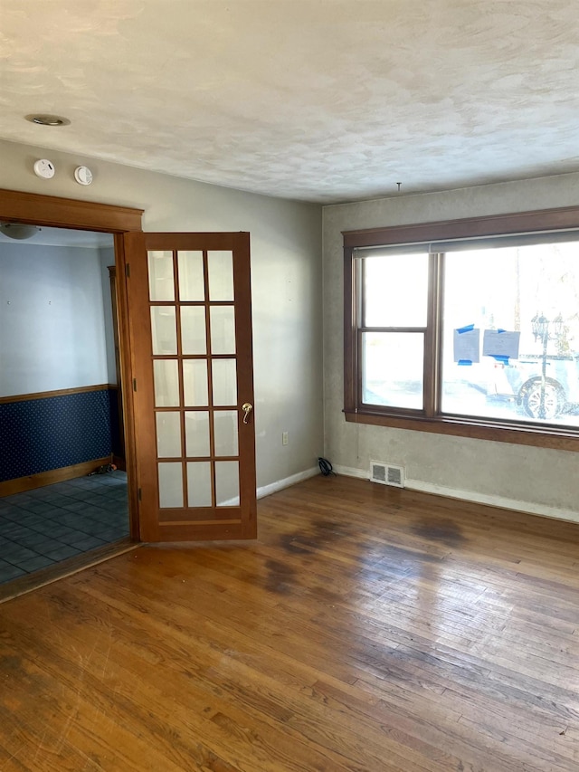 spare room featuring dark hardwood / wood-style floors and a textured ceiling