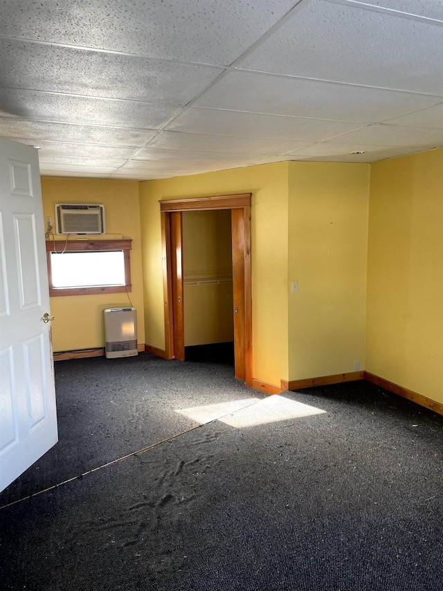 spare room featuring dark carpet and an AC wall unit