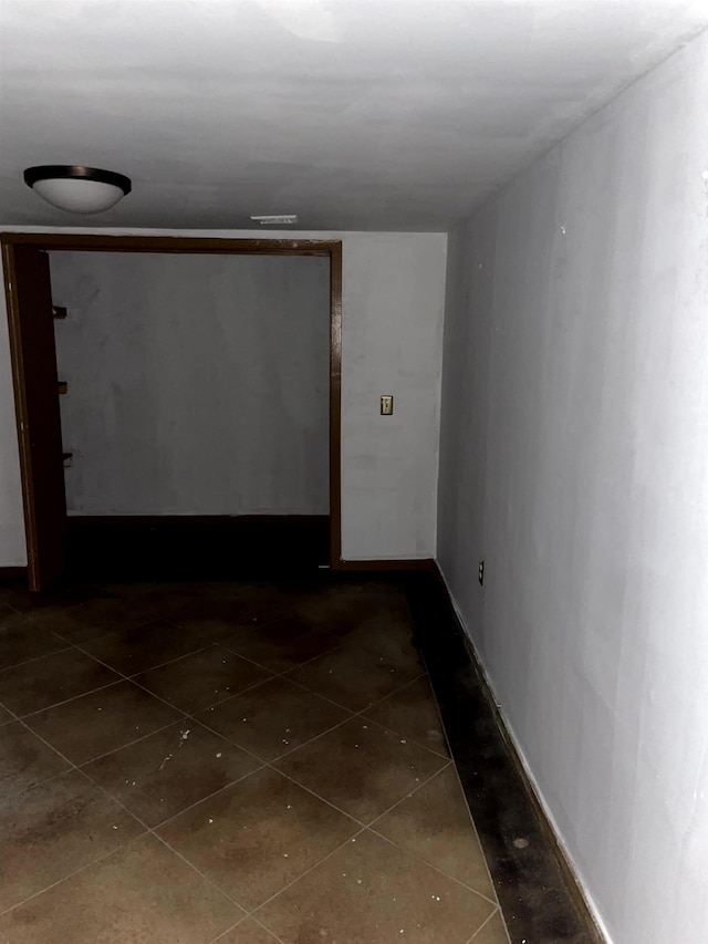 hall with dark tile patterned floors