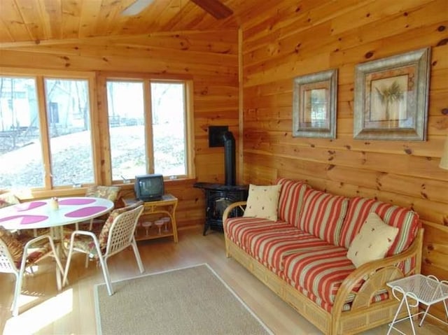 sunroom with lofted ceiling, a wood stove, and wood ceiling