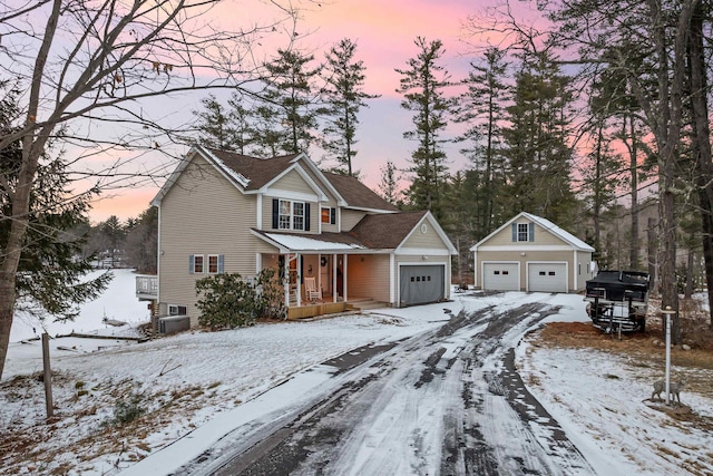 view of front of home with a porch, a garage, an outdoor structure, and central AC unit