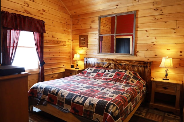 bedroom featuring vaulted ceiling and wood walls