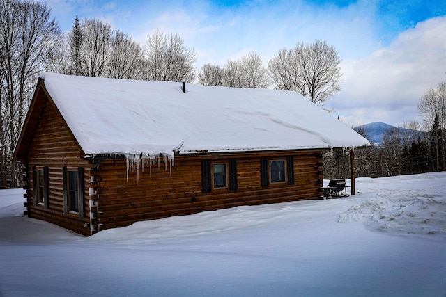 snow covered rear of property with a mountain view