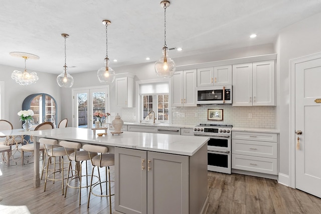 kitchen with pendant lighting, double oven range, a center island, and white cabinets