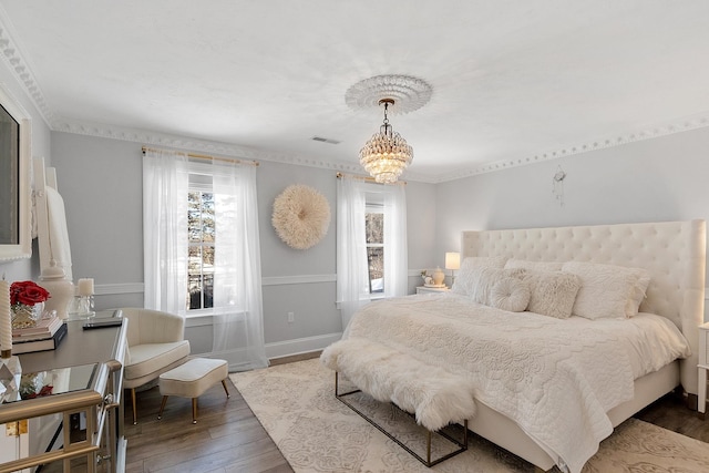 bedroom featuring an inviting chandelier and hardwood / wood-style floors