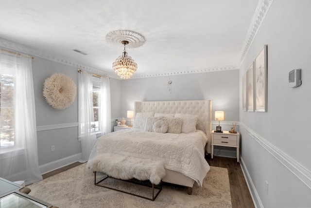 bedroom with wood-type flooring and a notable chandelier