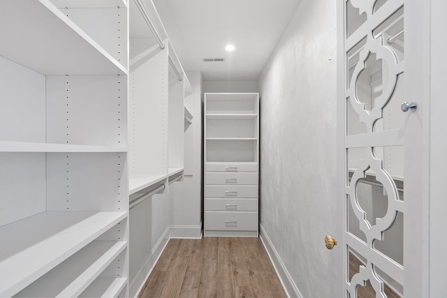 walk in closet with hardwood / wood-style flooring