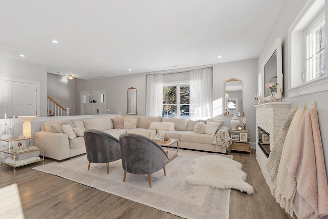 living room featuring a brick fireplace and wood-type flooring