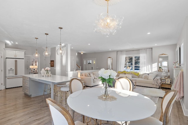 dining area featuring an inviting chandelier and light hardwood / wood-style flooring