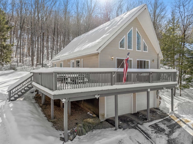 snow covered property featuring a garage and a deck