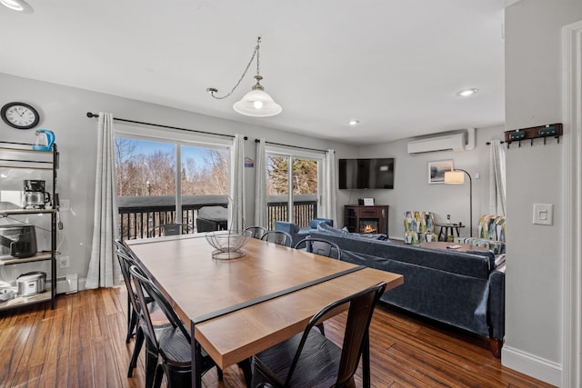 dining room with dark hardwood / wood-style flooring and an AC wall unit