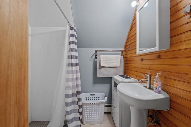 bathroom featuring a shower with curtain, wooden walls, vaulted ceiling, and baseboard heating