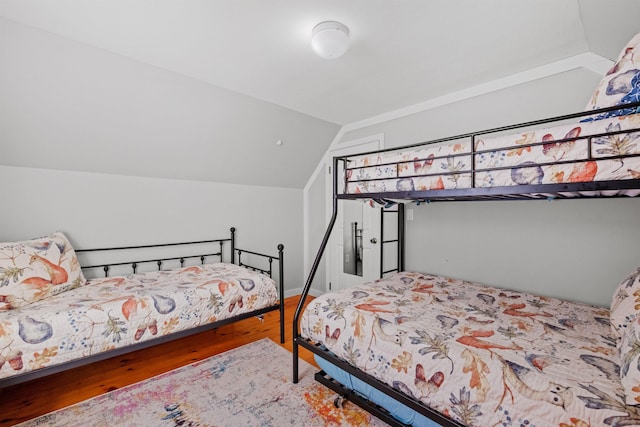 bedroom with lofted ceiling and wood-type flooring