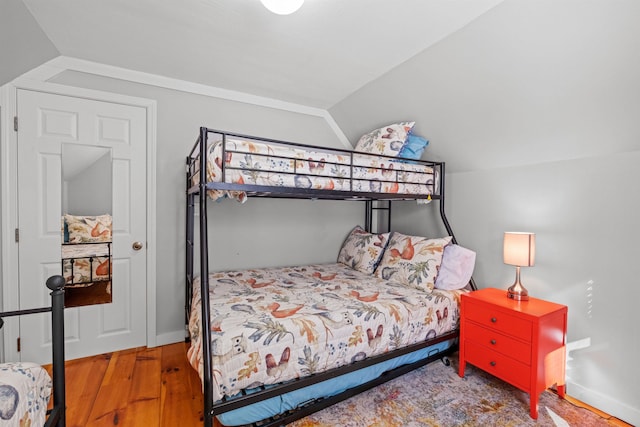 bedroom with hardwood / wood-style flooring and lofted ceiling